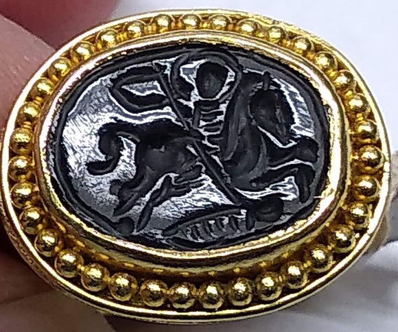 This 22k gold ring features an etching of a man on  horseback holding a banner carved into it's solo black stone. Our best guess is that it's St. George and the Dragon.  Size 7 1/4